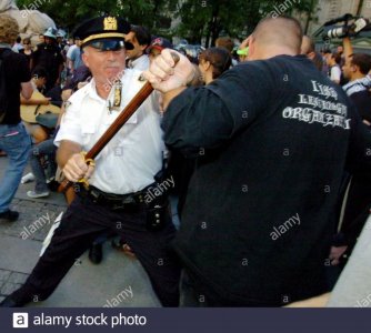 a-new-york-city-police-officer-uses-his-nightstick-on-a-protester-during-a-protest-in-front-of...jpg