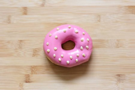 top-view-of-pink-donut-on-wooden-table-picture-id1278112528.jpg