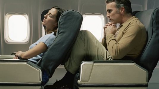 0_Male-passenger-with-knees-against-female-passengers-seat-on-aeroplane.jpg