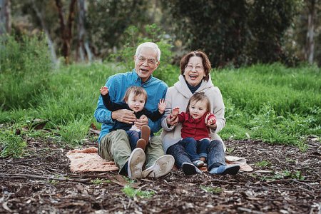 portrait-of-senior-active-couple-holding-twin-granddaughters-outside-cavan-images.jpg