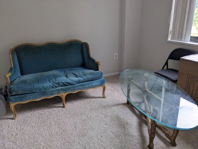 grungy loveseat and glass coffee table.jpg