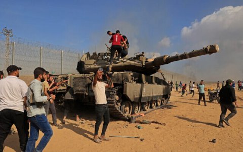 Palestinians take control of an Israel tank after crossing border fence.jpg