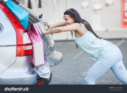 stock-photo-woman-trying-to-pack-her-retail-into-the-car-not-enough-space-for-the-purchase-sho...jpg