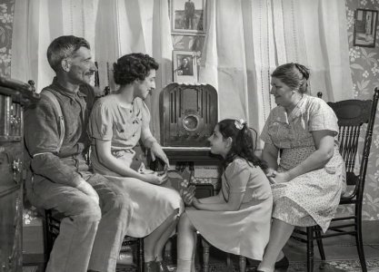 fisherman and his family gathered around a radio in their living room in Provincetown, Massach...jpg
