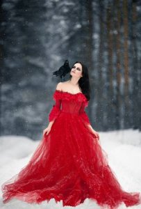 70201202-woman-witch-in-red-dress-and-with-raven-on-her-shoulder-in-snowy-forest-her-long-dres...jpg